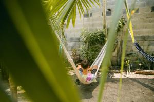 a young girl laying on a hammock in a swing at Casa Austera in El Paredón Buena Vista