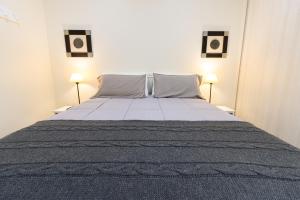 um quarto com uma cama grande e 2 candeeiros em Waia Apartments em Ushuaia