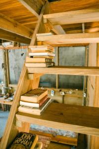 a stack of books sitting on a wooden shelf at Casa Austera in El Paredón Buena Vista