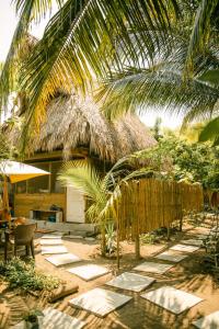 a resort with a table and chairs under a palm tree at Casa Austera in El Paredón Buena Vista