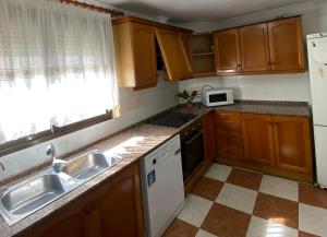 a kitchen with wooden cabinets and a sink and a window at Borriana Bonica in Burriana