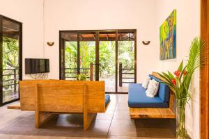 un soggiorno con divano blu e TV di Villa Ángel (AC/Internet/Pool/Punta Uva beach) a Punta Uva