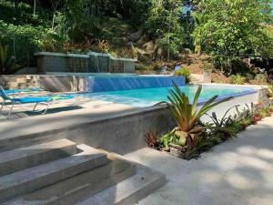 a swimming pool with stairs and a chair next to it at Villa Ángel (AC/Internet/Pool/Punta Uva beach) in Punta Uva