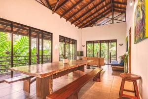 un comedor con una gran mesa de madera y bancos en Villa Ángel (AC/Internet/Pool/Punta Uva beach) en Punta Uva