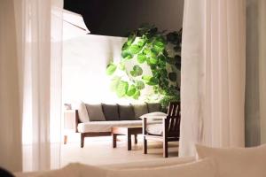 a living room with a couch and some plants at The Sanya EDITION in Sanya