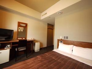 a hotel room with a bed and a desk at Hotel Route-Inn Abashiri Ekimae in Abashiri