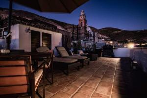 a rooftop patio with chairs and a clock tower at night at HOTEL MINA REAL in Real de Catorce