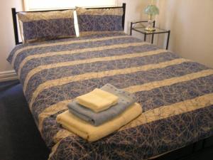 a bedroom with a bed with towels on it at Heritage Haven on Phillip Island in Cowes