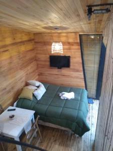 - une chambre avec un lit vert et une table dans l'établissement Modo tiny relax spa, à Duggan