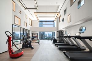 un gimnasio con cintas de correr y máquinas elípticas en RiZhao Mumian Hotel, en Rizhao