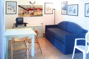 a living room with a blue couch and a table at Apartment in Palau near Surfing Paradise in Porto Pollo