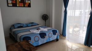 ein Schlafzimmer mit einem Bett in einem Zimmer mit einem Fenster in der Unterkunft Hotel Luis Ángel in Mocoa
