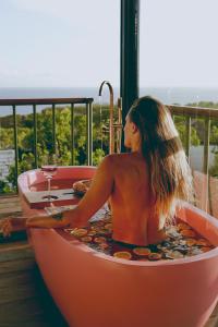 a woman in a bath tub with a glass of wine at Salty Breeze Bali in Ungasan