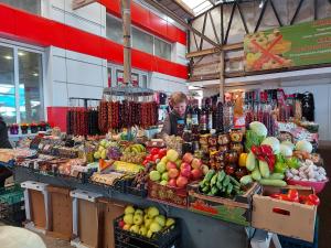 una persona parada detrás de un puesto de fruta en un mercado en Апартаменты Esnat en Gudautʼa