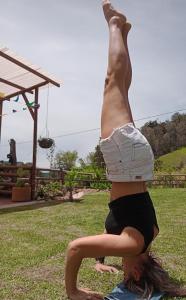 a woman doing a handstand in the grass at EcoGranjasYa in El Peñol