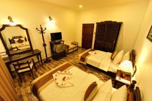 ウダワラウェにあるCentauria Wildのベッド2台と鏡が備わるホテルルームです。