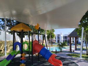 um parque infantil com escorrega num parque em Casa en privada con alberca, Excelente para vacaciones y descanso em Playa del Carmen