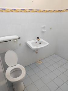 een witte badkamer met een toilet en een wastafel bij Villa Sayang Humairah @ Venice of Perak Intan 2 in Lumut