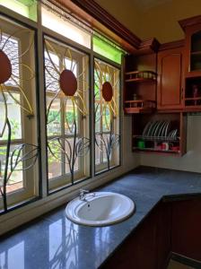 een badkamer met een wastafel en 2 ramen bij Villa Sayang Humairah @ Venice of Perak Intan 2 in Lumut