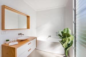 Un baño con lavabo, espejo y una planta. en Beach Life on Beach, en Dunsborough 30 fotos más