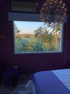 a bedroom with a large window with a view of a bed at Posada de Sofi in Concordia