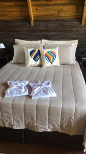 a large white bed with pillows on top of it at Refugio monte itapeva in Torres