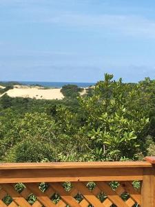 a wooden bench with a view of a beach at Refugio monte itapeva in Torres