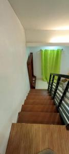 a staircase with a green window and a green curtain at Misty Hills Guesthouse Amadeo - Tagaytay in Amadeo