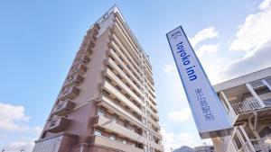 a tall building with a sign in front of it at Toyoko Inn Higashi hiroshima Ekimae in Higashihiroshima +33 photos