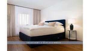 ein Schlafzimmer mit einem großen Bett mit weißer Bettwäsche und Kissen in der Unterkunft Apartment Leinetal - 3 Zi 70 qm ,Küche, Duschbad, Parkplatz in Northeim