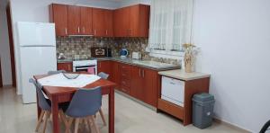 Una cocina con gabinetes de madera y una mesa con sillas. en Comfort Apartments, en Kefalos