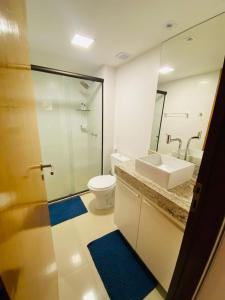 y baño con lavabo, aseo y espejo. en Nomar X - Lindo Apartamento à 50MTS mar, en João Pessoa