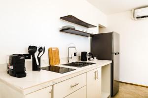 a kitchen with white cabinets and a black refrigerator at L'Avventura Boutique Hotel in Tamarindo