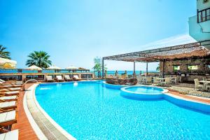 a large swimming pool with chairs and a resort at Xenios Possidi Paradise Hotel in Possidi