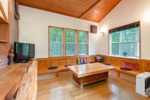 S-villa Nasu Audrey في ناسو: غرفة معيشة مع طاولة وتلفزيون