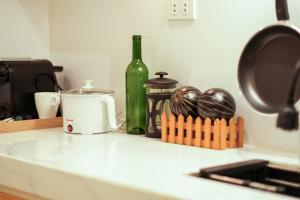 a kitchen counter with a bottle of wine and a toaster at The House of Windsor - QC in Manila