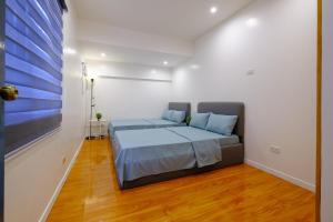 um quarto com uma cama com almofadas azuis em The House of Windsor - QC em Manila
