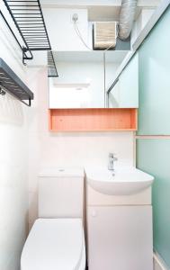 a small bathroom with a toilet and a sink at Shared dormitory Wan Chai Road 187 in Hong Kong