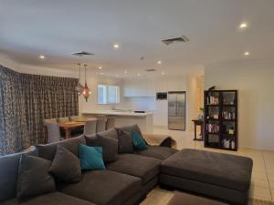 a living room with a couch and a kitchen at Terrigal Sails Serviced Apartments in Terrigal