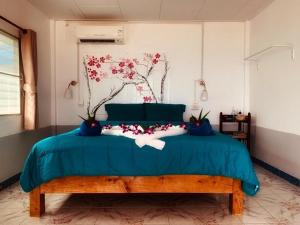 a bedroom with a blue bed with flowers on it at Sabai Beach Resort in Ko Mak