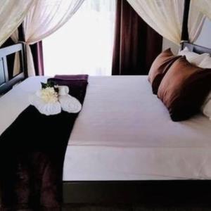 a bed with two towels and flowers on it at Baan Soulmates in Ban Khung Tanot