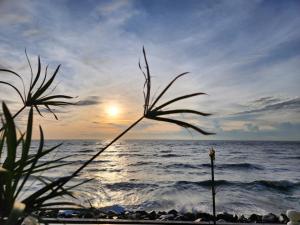 een uitzicht op de oceaan met de zon in de horizon bij Baan Soulmates in Ban Khung Tanot