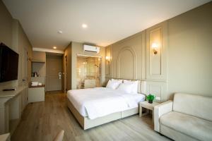 1 dormitorio con cama blanca y sofá en Eurana Boutique Hotel, en Chiang Mai