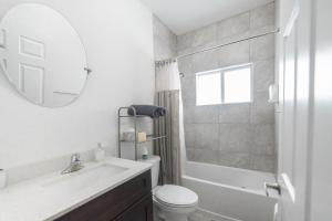 ein Badezimmer mit Waschbecken, Toilette und Spiegel in der Unterkunft New house on the block near Miami Airport. in Miami