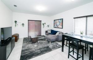 uma sala de estar com uma mesa e um sofá em New house on the block near Miami Airport. em Miami