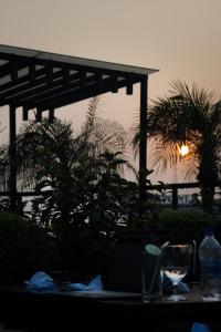 a table with a sunset in the background with palm trees at Hotel Milina Uttara in Dhaka