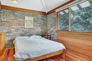 a bedroom with a bed and a brick wall at Seaside Serenity Getaway in Hawks Nest