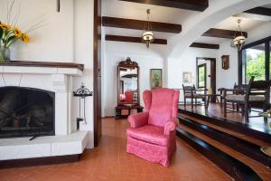 sala de estar con silla rosa y chimenea en Casa Bella Vista en Kalathas