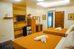 ein Hotelzimmer mit 2 Betten und einem TV in der Unterkunft Youhan Beach Resort in San Antonio
