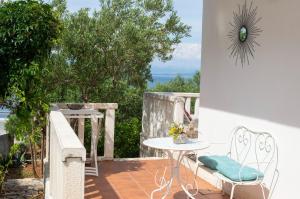 eine Terrasse mit einem Tisch und Stühlen auf dem Balkon in der Unterkunft Apartment Ela - very close to beach in Rogač